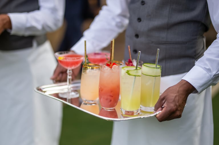 Waiter serving colorful cocktails on a silver tray