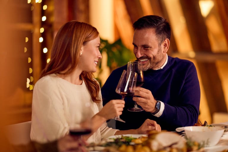 Couple share a toast at a warmly lit dinner