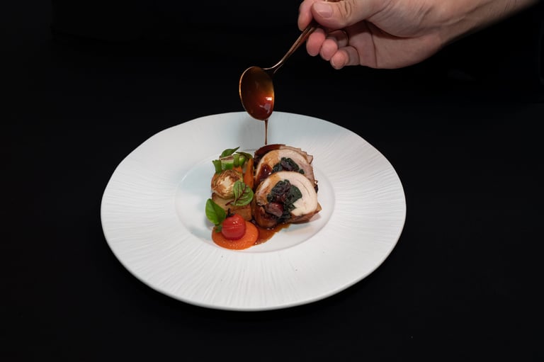 Chef delicately garnishing a beautifully plated gourmet meal ready to be served