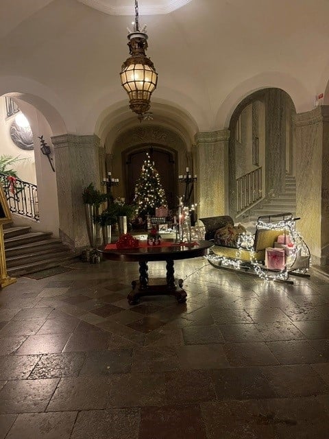 Elegant hallway with arched ceiling, pendant light, and round table decorated with Christmas tree and candles